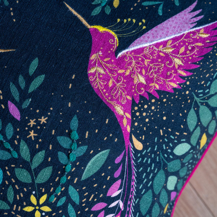 Close up of hummingbird with embroidery and linen texture.