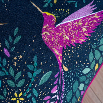 Close up of hummingbird with embroidery and linen texture.