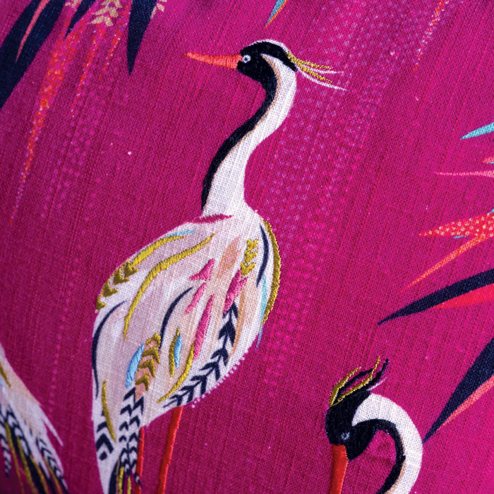 Close up on pink cushion with heron design and embroidery, linen texture.