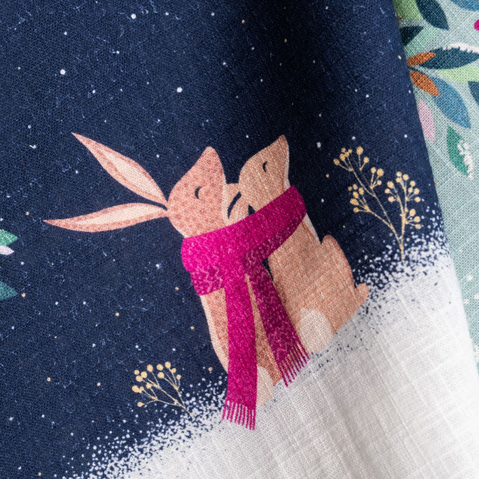 Festive tea towel with rabbits in a moonlit scene.