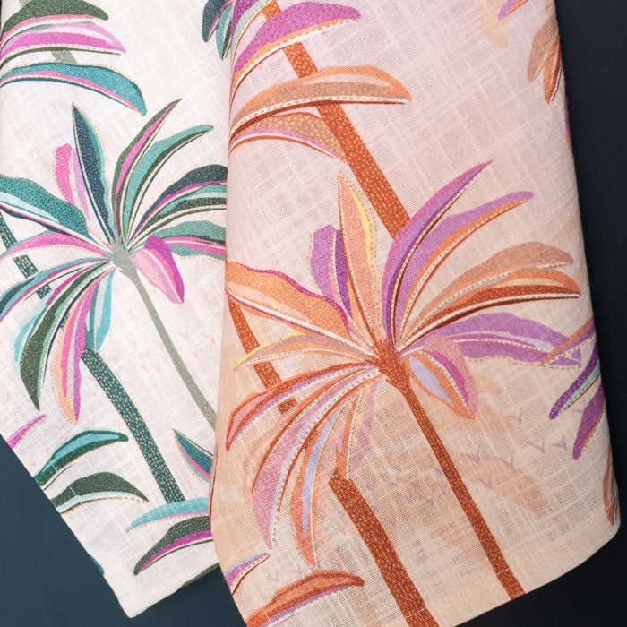 Pink and orange tea towel with palm tree design.