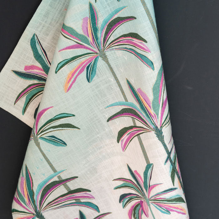Pink and blue tea towel with palm tree design.