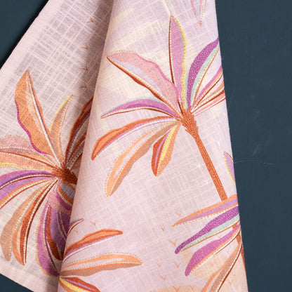 Pink and orange tea towel with palm tree design.