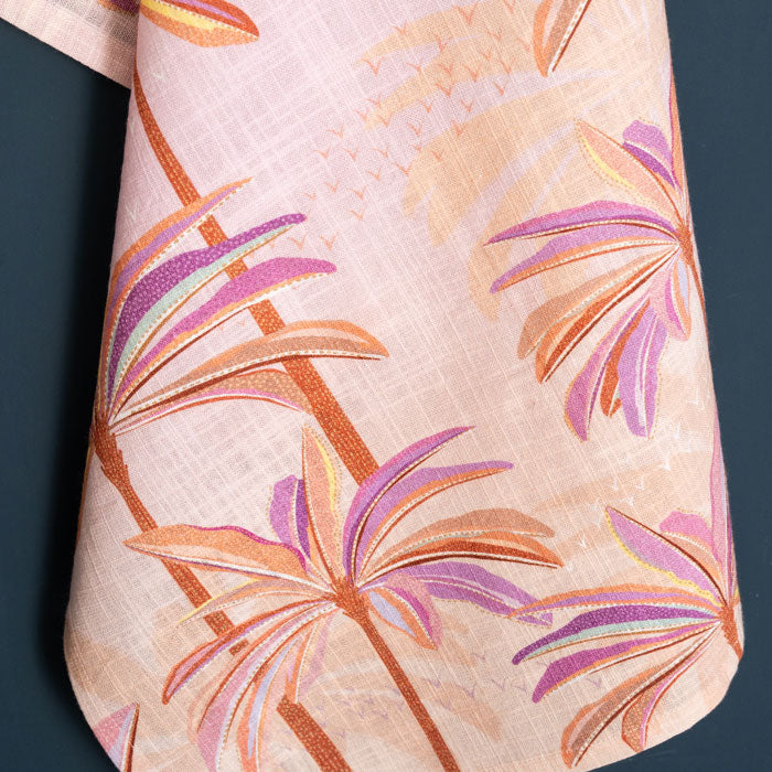 Pink and orange tea towel with palm tree design.