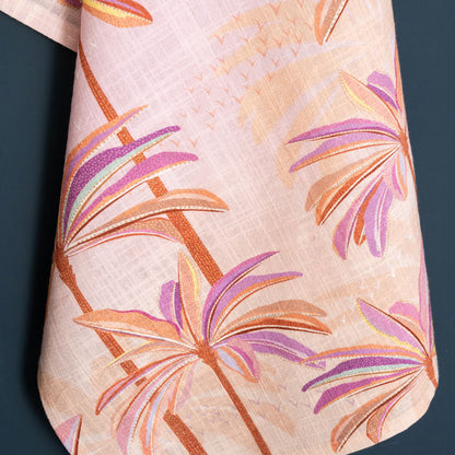 Pink and orange tea towel with palm tree design.