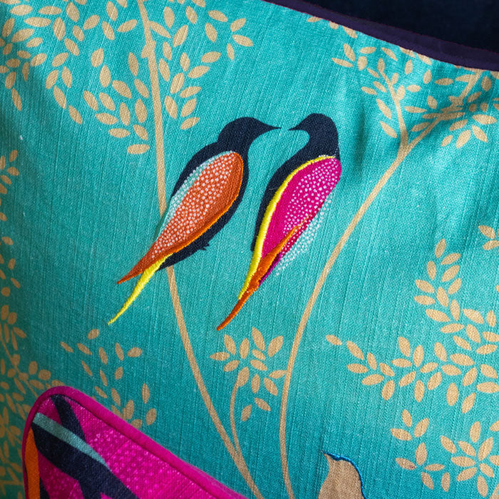 Close up of embroidered birds and linen texture.