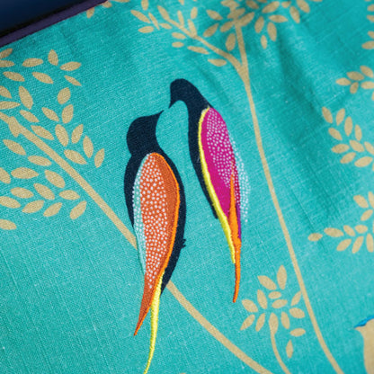 Close up of embroidered birds and linen texture.