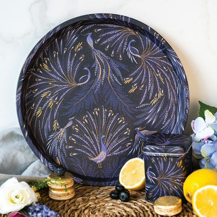 Round tin tray with peacock parade design, swooping tail feathers in velvety indigo.