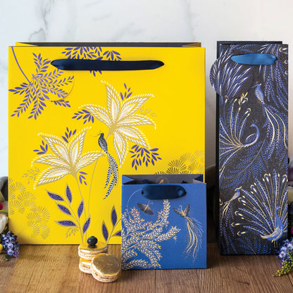 Three anniversary collection gift bags in different colours and designs, including yellow gift bag.