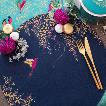 Navy round placemat with hummingbird design and foliage.
