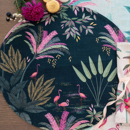 Round placemat with tropical leaf and flamingo design with a navy background.