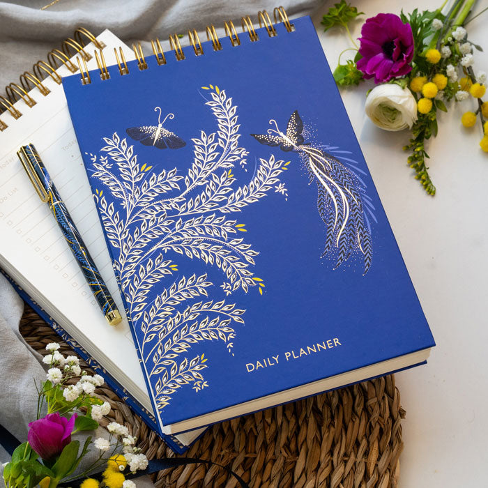 Blue daily planner with butterfly design on a cobalt blue background.