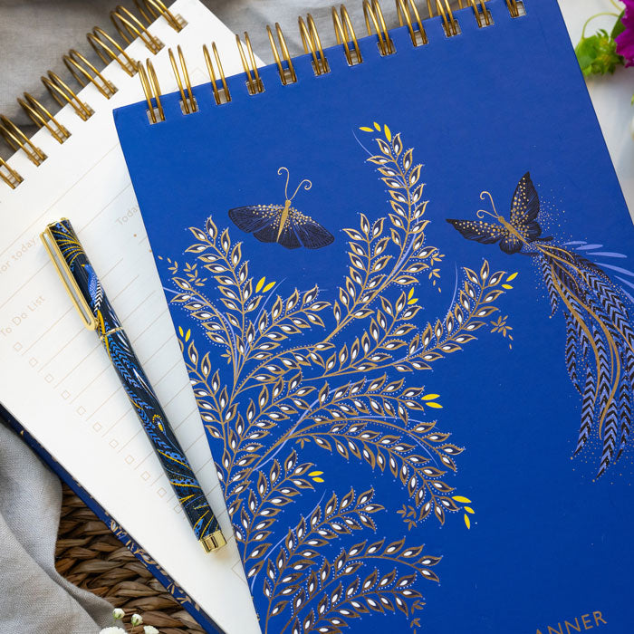 Blue daily planner with butterfly design on a cobalt blue background.