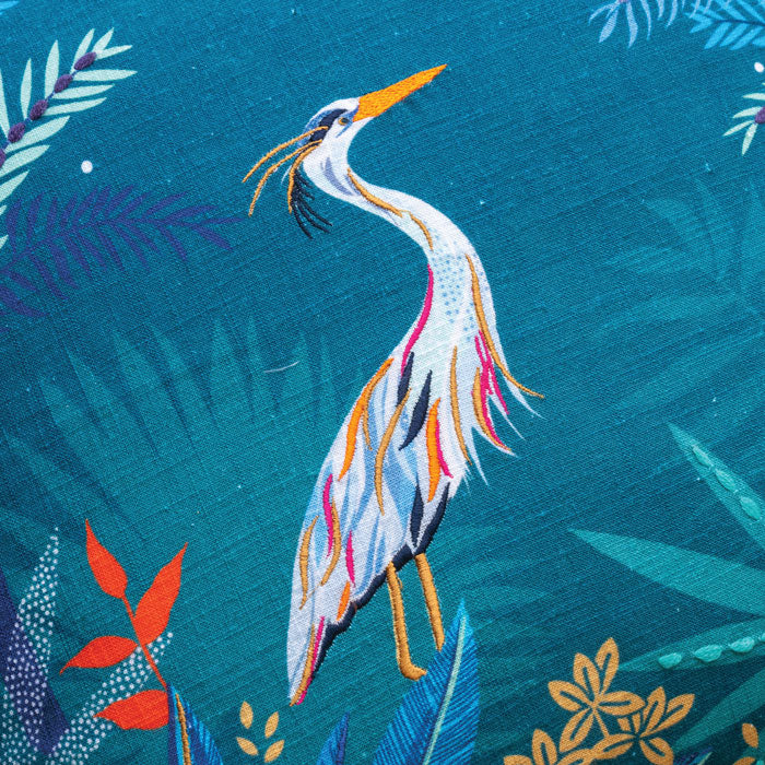 Close up of heron design with embroidery on teal cushion.
