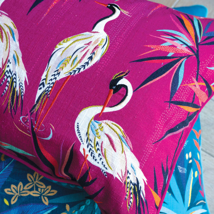 Close up on pink cushion with heron design and embroidery, linen texture.