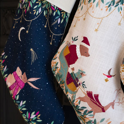 Two Christmas stockings with festive designs, one featuring a night sky with stars and animals, the other with a winter scene with bear and reindeer.