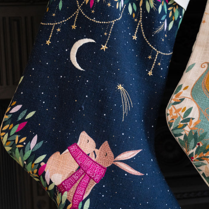 Embroidered stocking with rabbits under a starry sky design.