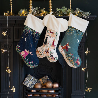 Three decorated Christmas stockings hanging above a fireplace with decorative items.