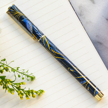 Ballpoint pen presented in box, with peacock feathers design in indigo and gold.