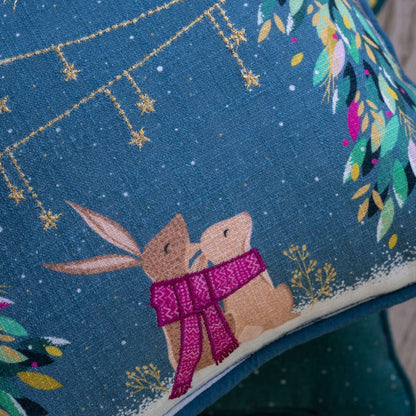 Embroidered design of two bunnies holding hands with a pink scarf against a blue background with stars and foliage.