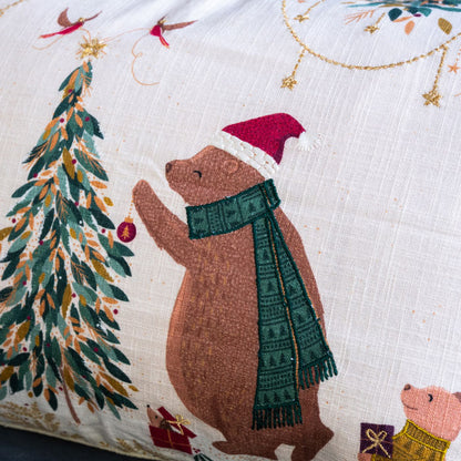 Decorative pillow with a bear and Christmas tree design on a cream background