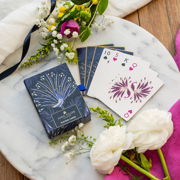 Playing cards with peacock feathers design on an indigo background. Shows presentation box in matching design.
