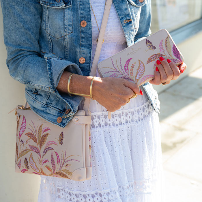 Model holding the large zip purse, and wearing matching crossbody bag.