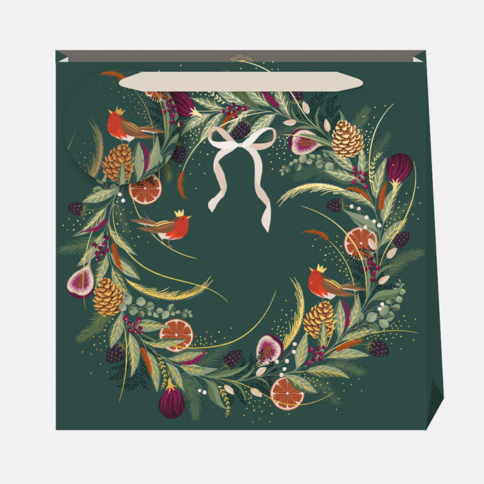 A dark green gift bag with traditional festive wreath design with robins and bow.
